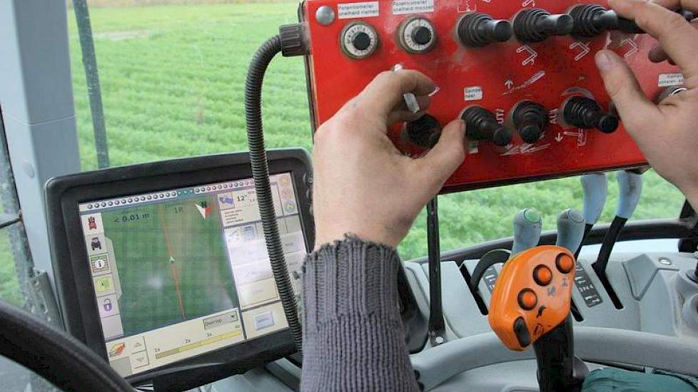 De chauffeur van de rooier zorgt er voor dat de peen netjes in de kisten komt.