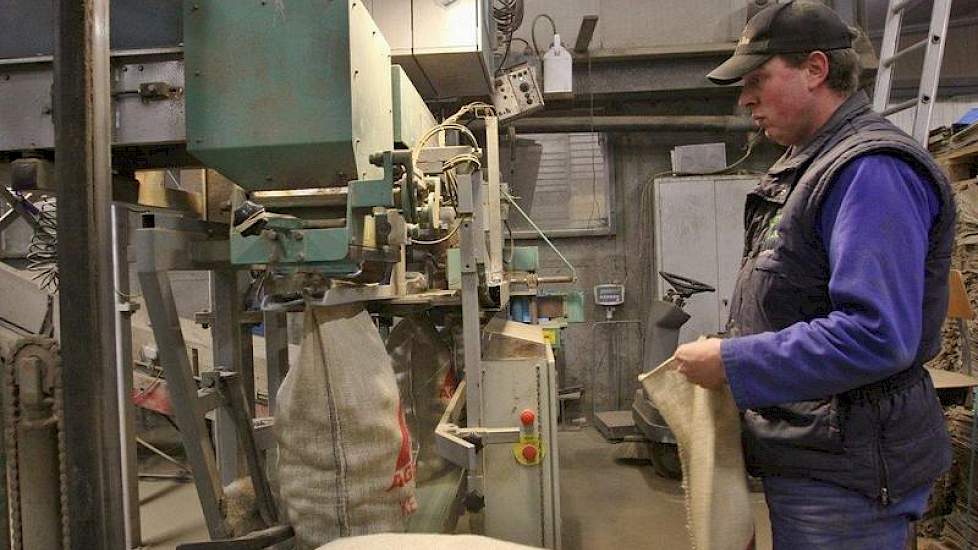 Joahn Rietkerk zakt de aardappelen op en naait de zakken dicht.