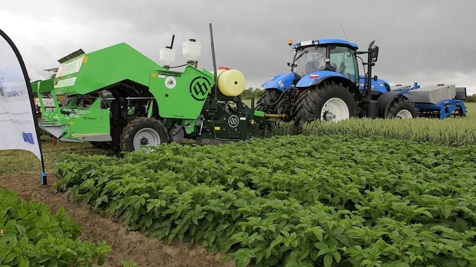 Bij het proefveld met aardappelen staat een ‘all-in-one’-pootcombinatie, die in één werkgang de grond klaarlegt, fosfaat in de rij strooit, aardappelen poot, een rhizoctoniabehandeling uitvoert, stikstof in de rij geeft en de rug opbouwt. „Een mooie ontwi