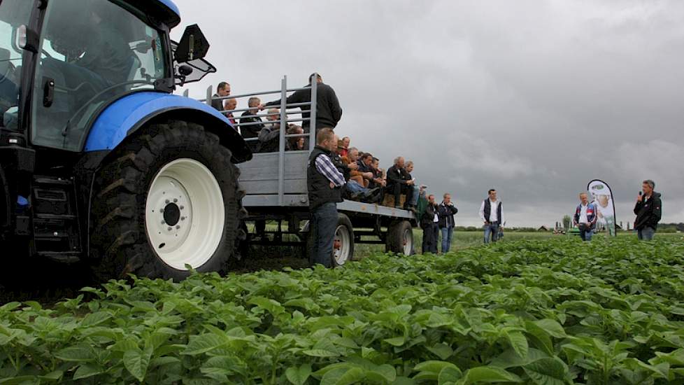 Op platte wagens langs de proefvelden.