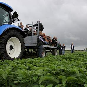 Op platte wagens langs de proefvelden.