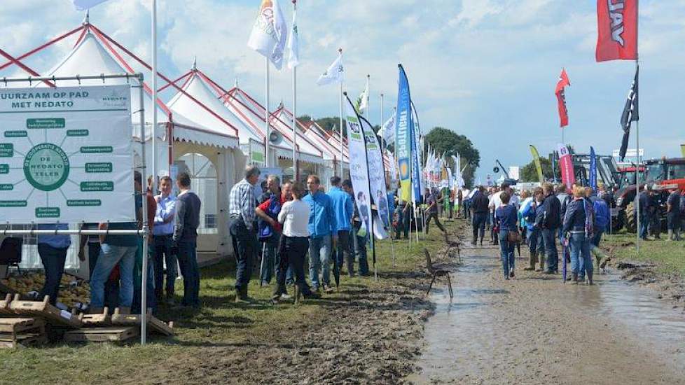 Zowel buiten als binnen is een bedrijvenmarkt met ruim 70 bedrijven. Het pad op het buitenterrein is door de regen veranderd in een modderpoel.