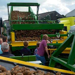 Achter op het erf worden de gerooide aardappelen via 5 loslijnen op vrachtwagens geladen.