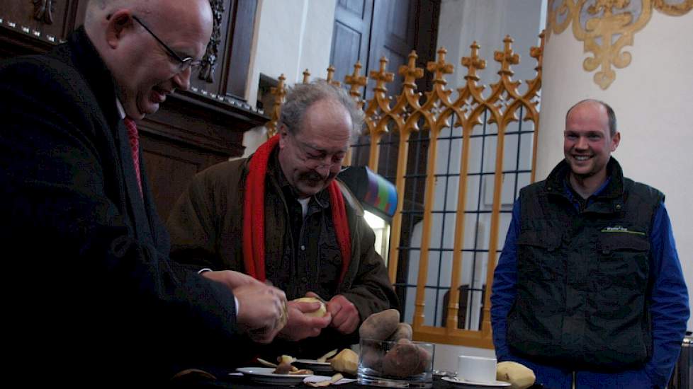 Gedeputeerde Henk Staghouwer (links) doet een wedstrijdje aardappelschillen met Wout Veldstra van gemeente Groningen. Akkerbouwer Erwin Westers kijkt toe. Provincie en gemeente Groningen doneerden ieder  duizend kilo aardappelen aan de voedselbank.