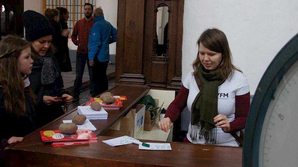 Hanneke Lestestuiver van de Youth Food Movement rekent aardappelen af voor klanten die voor zichzelf kopen en voor de voedselbank. Klanten waren op de hoogte van het initiatief via sociale media, bladen en de regionale omroepen.