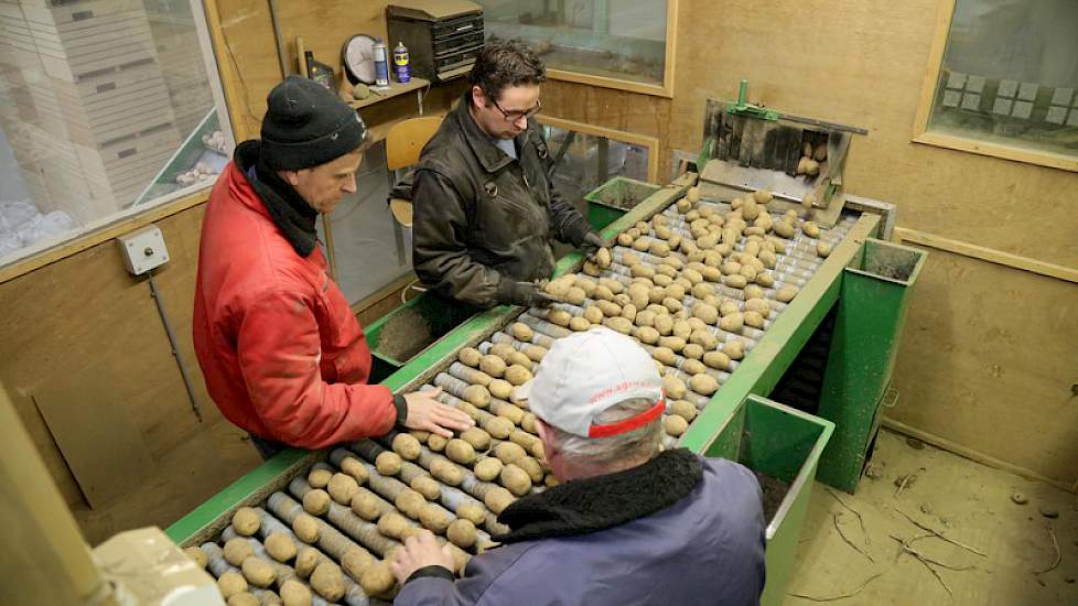 Chris Bos (rode jas) leest de poters samen met zijn schoonvader Guus Habets (voorgrond met pet) en zwager Marcel Habets.