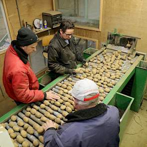 Chris Bos (rode jas) leest de poters samen met zijn schoonvader Guus Habets (voorgrond met pet) en zwager Marcel Habets.