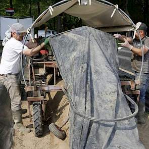 De oogstwagens tillen het doek op, waarna de medewerkers kunnen oogsten en daarna legt de wagen het doek weer keurig terug.