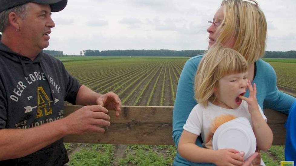 Hans Reijne vertelt over de teelt van witlofpennen aan een bezoekster met kinderen.
