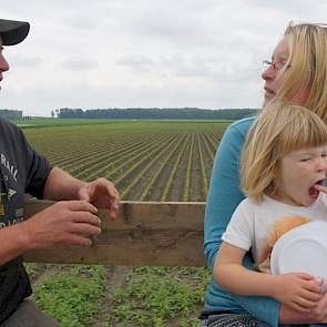 Hans Reijne vertelt over de teelt van witlofpennen aan een bezoekster met kinderen.