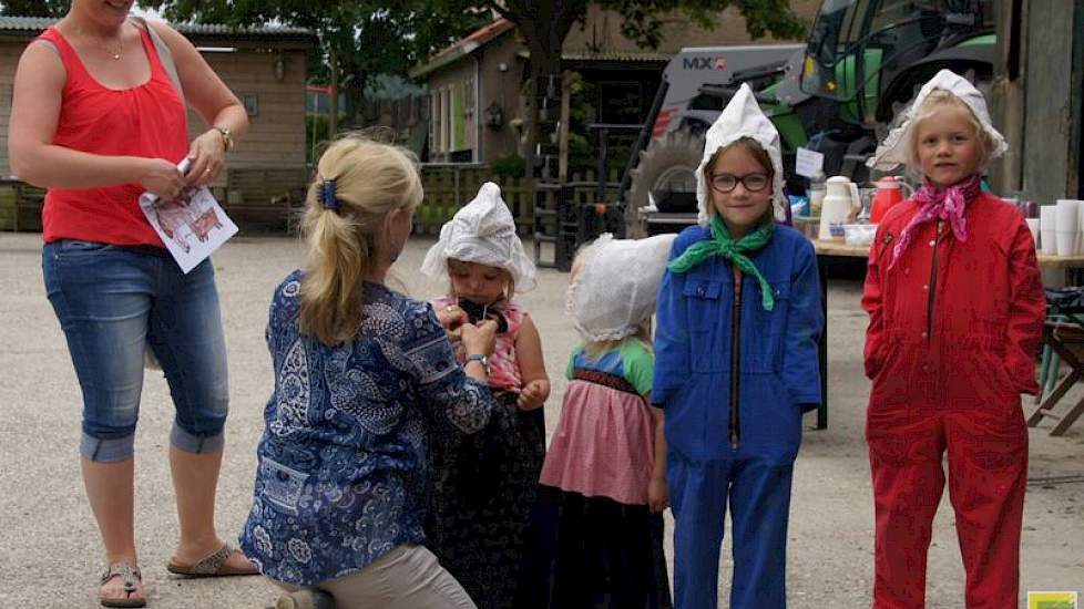 Verkleden als boer of boerin? Ineke Reijne helpt even met het mooi opzetten van een kanten mutsje.