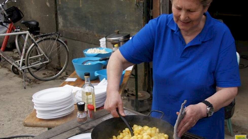 Op het erf van Reijne bakt 'oma Loes' aardappeltjes voor de gasten. „Ik kwam uit Amsterdam hier te wonen. In zo'n stad weet je vaak helemaal niet hoe landbouwproducten groeien. Het is leuk om de kinderen dat te laten zien.” Oma Loes is een vaste hulp bij