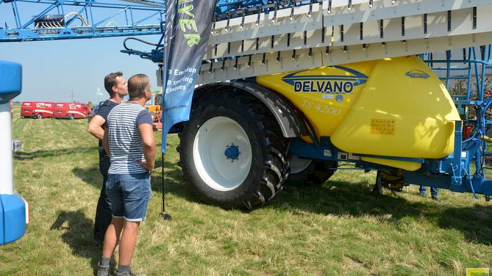 Enkele telers bestuderen een veldspuit van Delvano die is voorzien van een Wingssprayer-systeem. De spuit is van gebroeders Weststrate.