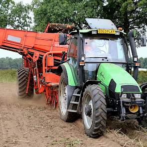 De akkerbouwer gebruikt een getrokken rooier van Grimme bij het werk.