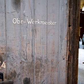 Overal vind je sporen van het Duitse verleden. In één van de hangars staan op de deuren nog de functies van degenen die werkten in de ruimtes er achter, zoals deze met de tekst Obr. Werkmeister. Op een tegenoverliggende deur staat Triebwerkschlosser.