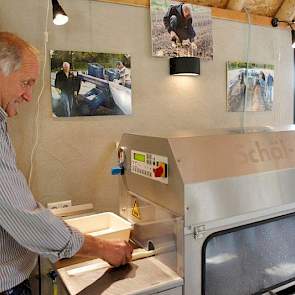 Met de schilmachine schilt hij asperges voor de verkoop in zijn winkel.