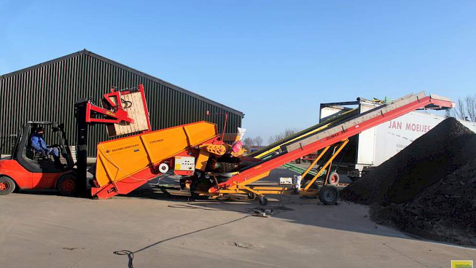 De stortbak met opvoerband richting vrachtauto en de transportband voor de afvoer van grond staan opzij van de bewaarloods.