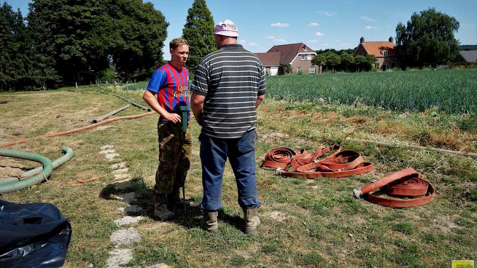Vakantiehulp Jordy (links) heeft de watermeter gehaald om het aantal millimeters beregeningswater goed in beeld te krijgen.