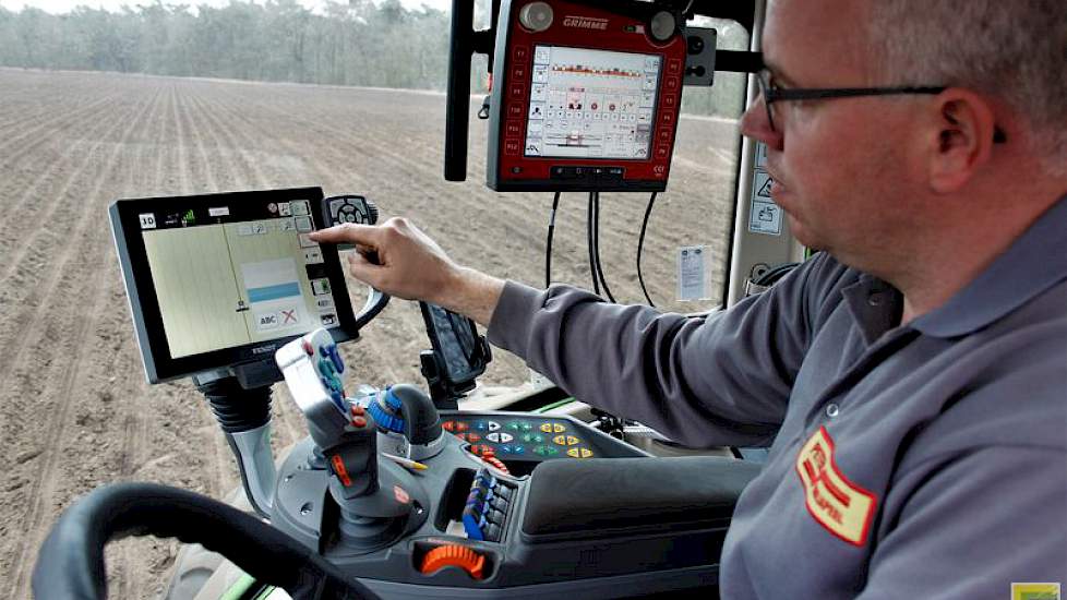 John Peters in de cockpit van de Fendt 516, vol met knoppen, schakelaars en schermen.