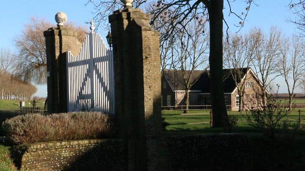 Zeer waarschijnlijk was de boerderij vroeger omgracht. De statige witte toegangspoort wijst hier nog op. De boerderij is ook veel groter en hoger dan anderen uit dezelfde tijd. Op de achtergrond de herbouwde en inmiddels uitgebreide arbeiderswoning waar n