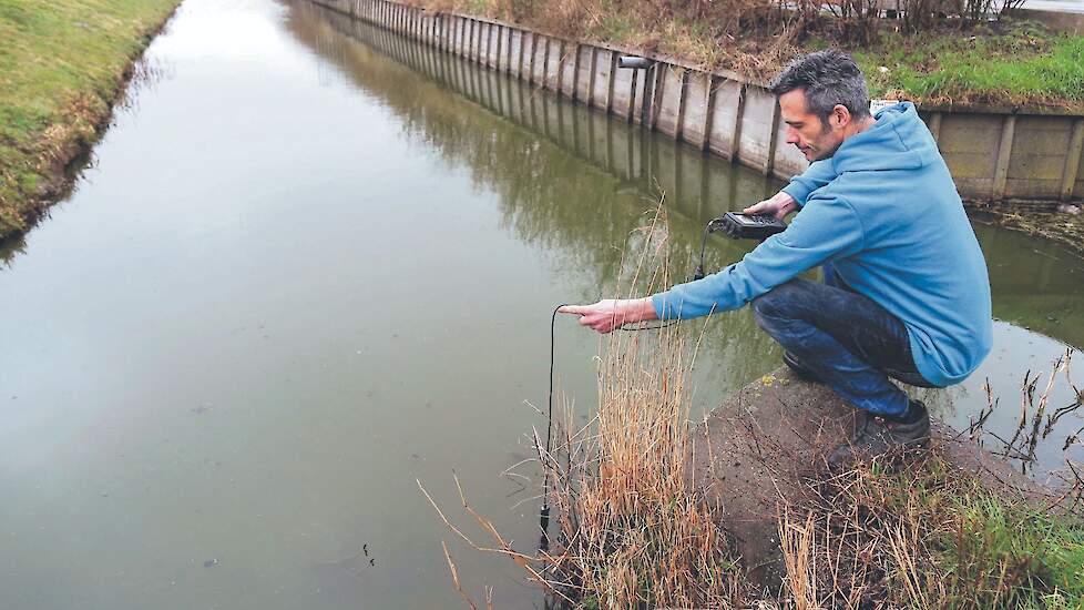 Groenteteler Bak heeft zijn bedrijf zo ingericht dat het beter bestand is tegen verzilting. Op de foto meet Bak de zoutgehaltes in het watersysteem rondom zijn bedrijf.