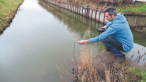 Groenteteler Bak heeft zijn bedrijf zo ingericht dat het beter bestand is tegen verzilting. Op de foto meet Bak de zoutgehaltes in het watersysteem rondom zijn bedrijf.