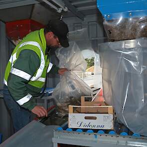 In de BeetBox wordt het monster verpakt. Een medewerker labelt de plastic zakken met de juiste gegevens.