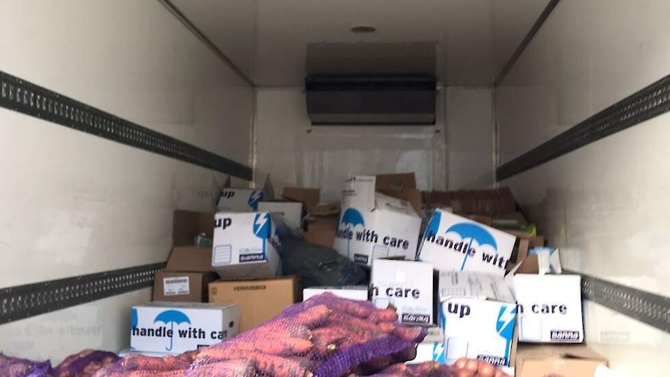 De witte dozen op de achtergrond zijn ingezameld in Zeist. In Oekraïne werd de vrachtwagen bijgevuld met wortels.