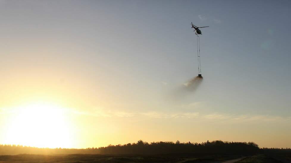 helikopter strooit kalk op de Veluwse natuur