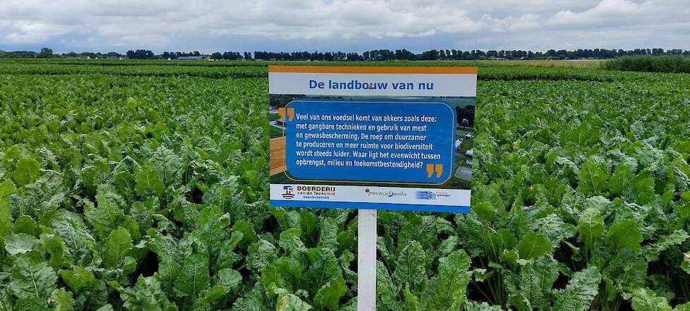 Bordje met uitleg, in een veld met een gewas