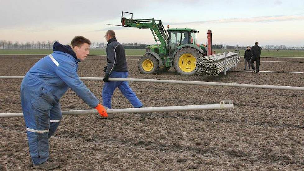 Medewerkers van bloembollenbedrijf Ton van der Lee uit De Goorn zijn op een perceel in Zuidoost Beemster bezig met het neerleggen van buizen voor een beregeningsinstallatie op tulpenland. Nu de grond bevroren is, werkt dat een stuk eenvoudiger. De buizen,