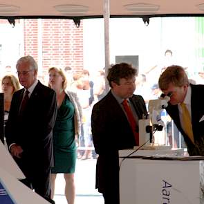 Eric Casteleijn (directeur NAK) geeft uitleg over grondonderzoek terwijl koning Willem Alexander door de microscoop kijkt.